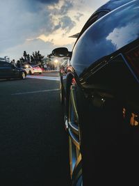 Close-up of cars on road against sky