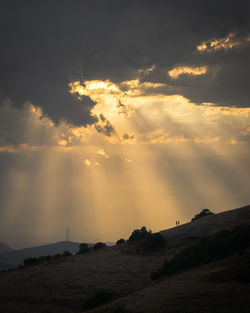 Couple walking in the mountains while the sun is setting.