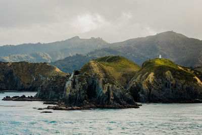 Scenic view of sea and mountains against sky