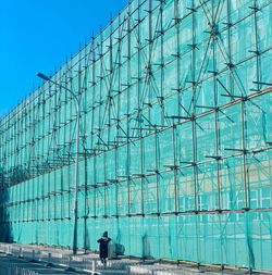 Person walking by scaffolding building in city