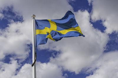 Low angle view of flag against cloudy sky