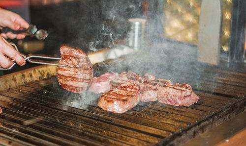 Person preparing food on barbecue grill