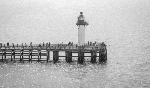 Lighthouse by sea against sky