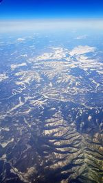 Aerial view of landscape against blue sky