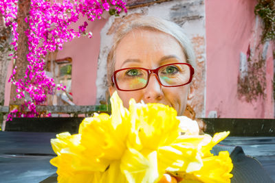 Portrait of young woman holding yellow flower