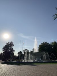 Fountain in city against clear sky