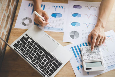 Cropped hands of businesswoman working over graph in office