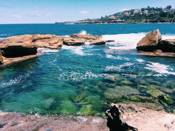 Rock formations by sea against sky