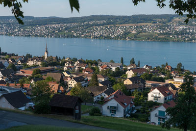 High angle view of townscape by sea against sky