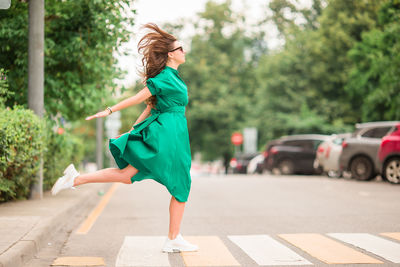 Side view of a young woman walking on road