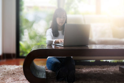 Young woman using mobile phone at home