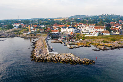 High angle view of townscape by sea against sky
