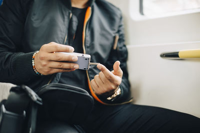 Man doing blood test with glaucometer while sitting in train