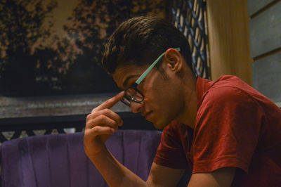 Portrait of young man sitting on sofa