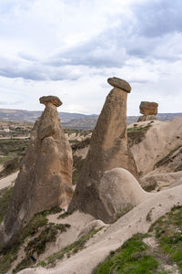 Stone structure on landscape against cloudy sky