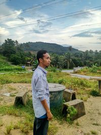 Full length of man standing on riverbank against sky