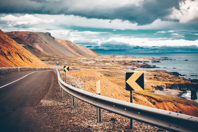 Rear view of man on road by sea against sky