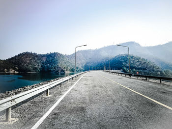 Road by mountains against clear sky