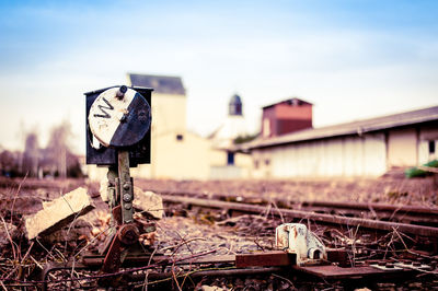 Close-up of abandoned railroad track against sky