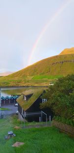 Scenic view of field against rainbow in sky