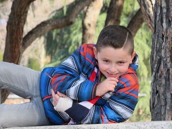 Portrait of boy lying on retaining wall