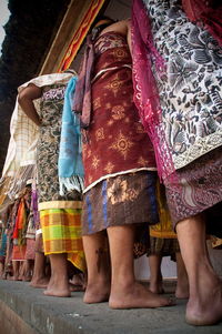 Low section of people standing on multi colored umbrellas