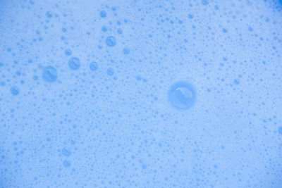 Close-up of water drops on blue surface