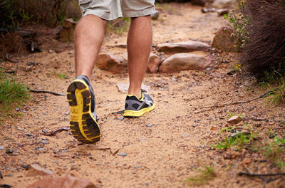 Low section of man walking on field