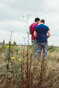 Rear view of man and son on field