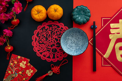 Chinese lunar new year decoration over red and black background. flat lay dinning table concept.