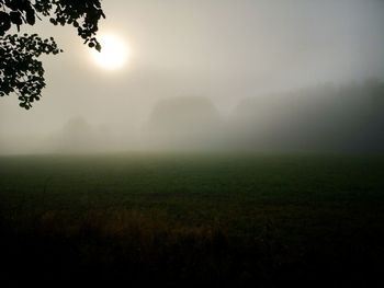 Scenic view of field against sky at foggy weather