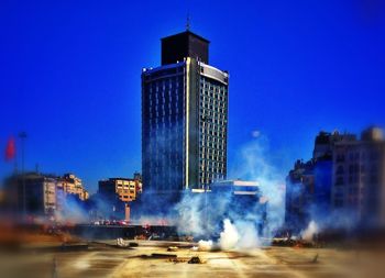 Buildings in city against blue sky