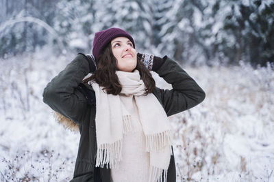 Young woman standing against snow covered land