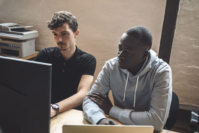 Computer programmers working on computer at workplace