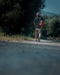 Rear view of man walking on road