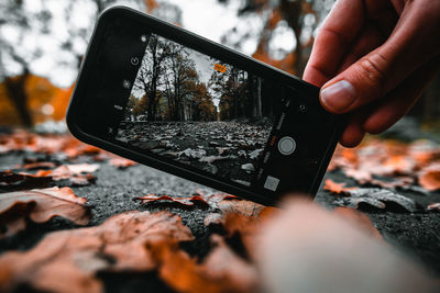 Midsection of person photographing with mobile phone