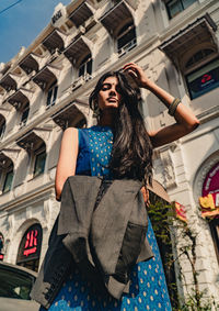 Low angle view of woman standing against building