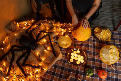 Midsection of woman decorating halloween pumpkin