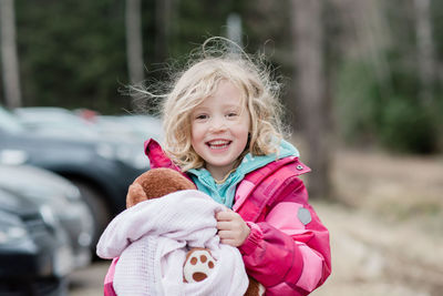 Candid portrait of a young girl smiling with messy hair and comforter