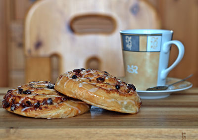 Two pieces of cake with a coffee cup in the background.