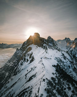 Scenic view of snowcapped mountains against sky during sunset