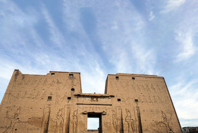 Low angle view of old building against cloudy sky