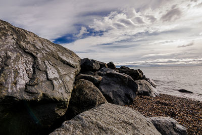 Rock formation on beach against sky