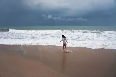 Full length of man standing on beach against sky