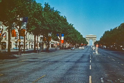 Road by trees against clear sky