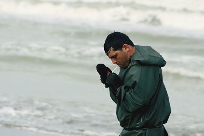 Man photographing while standing on beach