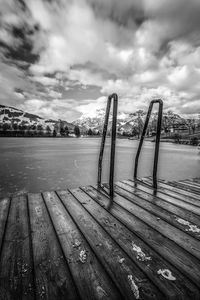 Wooden pier over lake against sky