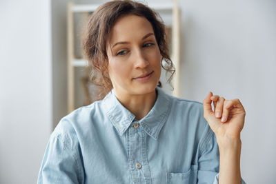 Portrait of young woman against wall