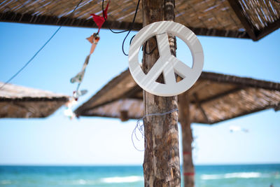 Low angle view of rope hanging by sea against sky