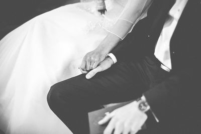 Midsection of newlywed holding hands